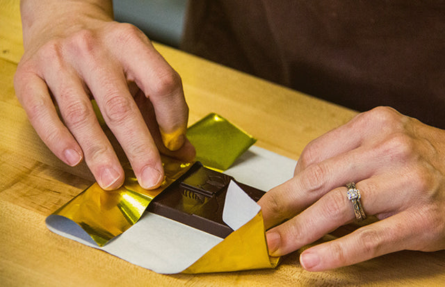 Packaging a chocolate bar in our gold wrapper.