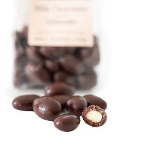 Close up of chocolate covered almond, showing thick layer of rich milk chocolate and roasted almond center