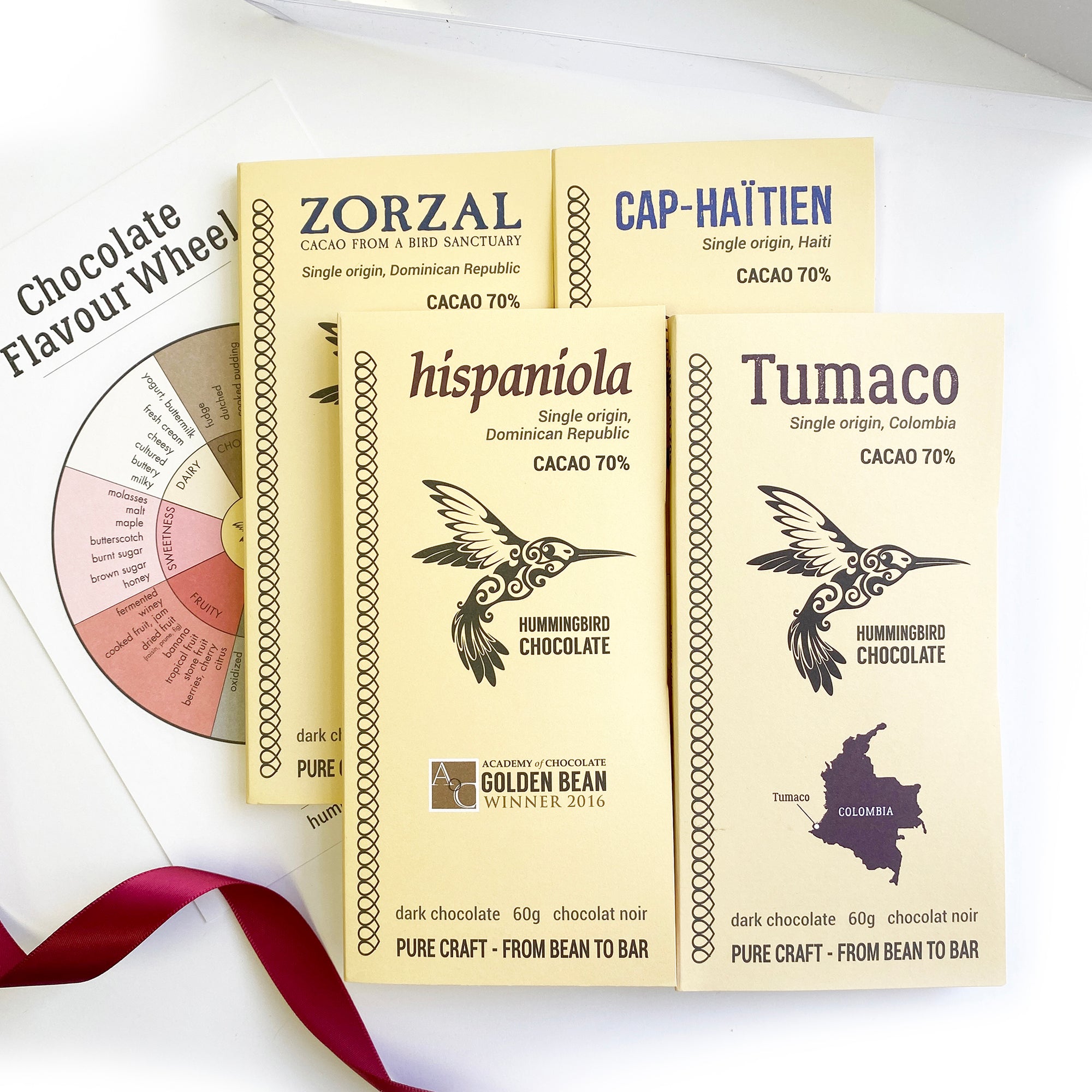 Hummingbird Chocolate, the 4 bars from Origins Collection presented outside of the box, along with Chocolate flavour wheel.