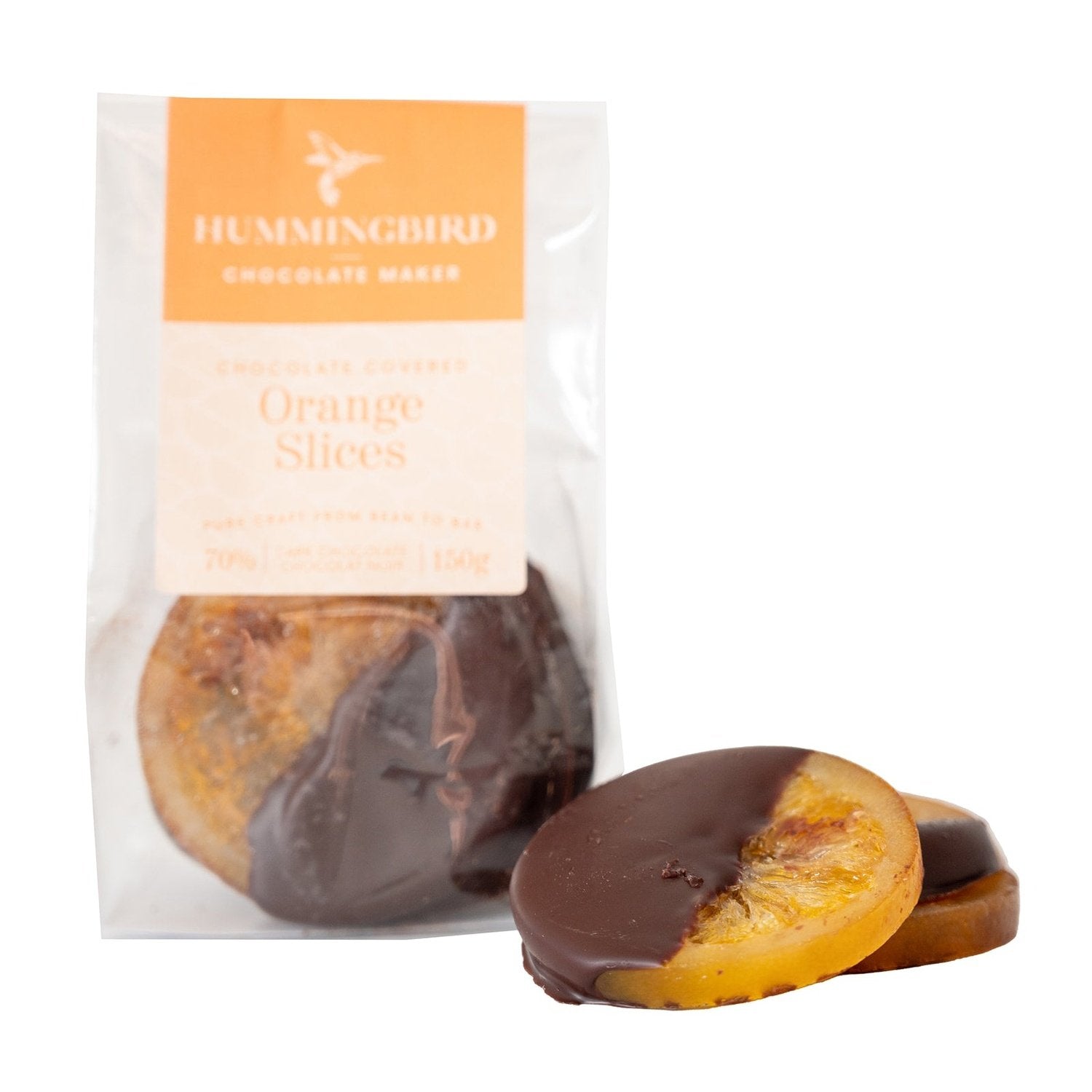 Chocolate covered candied orange slices stacked beside wrapped package from Hummingbird Chocolate Maker