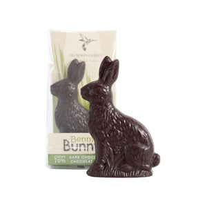 Unwrapped solid dark chocolate bunny in front of packaged product