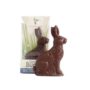 Unwrapped solid milk chocolate bunny with wrapped product in background